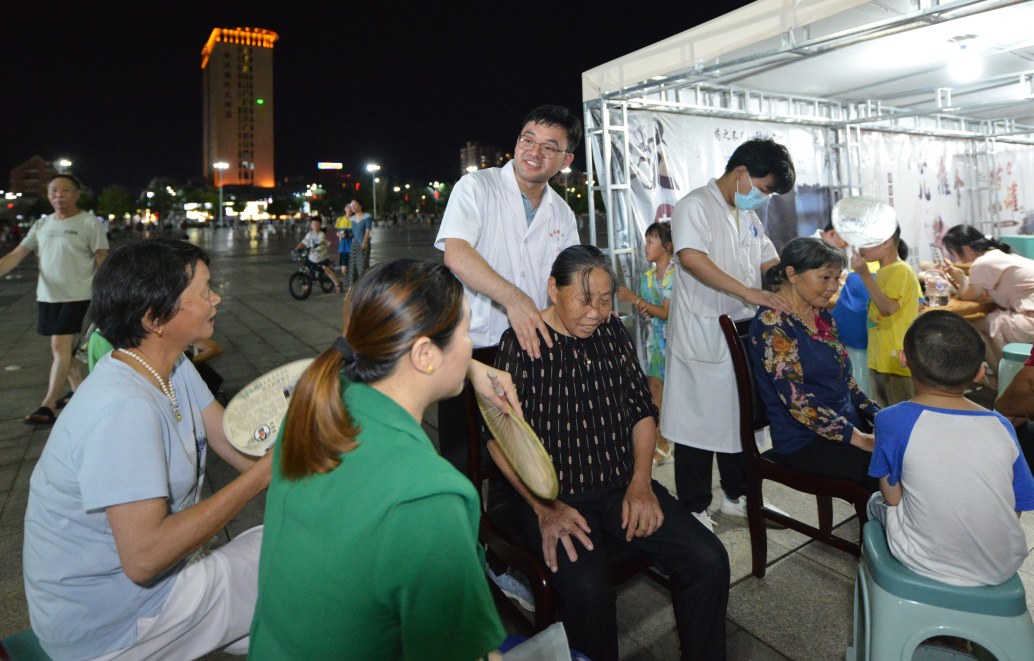 近日,在金溪县锦绣文化广场中医药健康夜市,医务工作者正忙着为群众